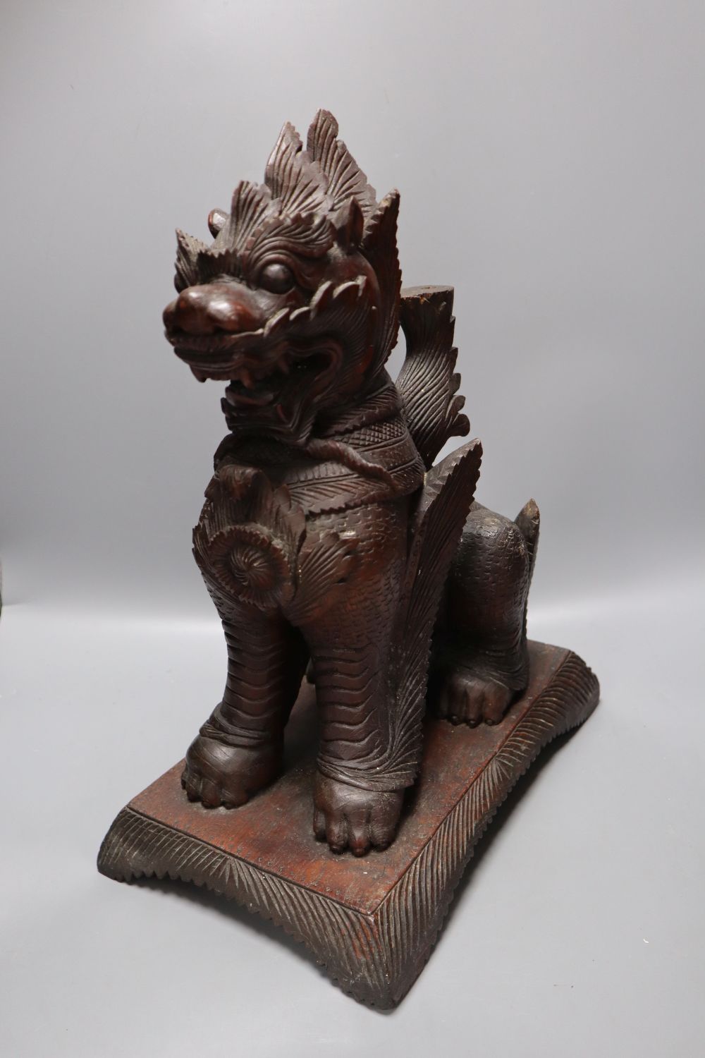 An Indonesian large carved wood model of a seated kylin, on plinth base and two Chinese rootwood carvings of elders, H approx 44cm (kyl